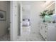Bathroom leading to bedroom, showcasing stylish vanity, modern fixtures, and white color scheme with illuminated mirror at 326 129Th E Ave, Madeira Beach, FL 33708