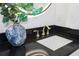 Bathroom vanity with modern black countertop, square sink, brass faucet, and illuminated mirror for a sleek aesthetic at 326 129Th E Ave, Madeira Beach, FL 33708