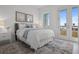 Cozy bedroom showcasing a bed, water view from a glass panel door, and beach artwork on the wall at 326 129Th E Ave, Madeira Beach, FL 33708