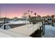 Luxury boat sits next to dock with views of the calm water, palm trees, and other houses in this waterfront community at 326 129Th E Ave, Madeira Beach, FL 33708