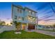 Stunning three-story home with a lush lawn, a two-car garage, and a charming outdoor space with a palm tree at 326 129Th E Ave, Madeira Beach, FL 33708