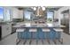 Gorgeous kitchen showcasing a blue island, white cabinets, stainless appliances, and barstool seating beneath pendant lights at 326 129Th E Ave, Madeira Beach, FL 33708