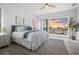 Bright main bedroom featuring a balcony with a beautiful sunset view, a ceiling fan, and light wood floors at 326 129Th E Ave, Madeira Beach, FL 33708