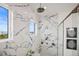 Luxurious walk-in shower with marble tile, dual showerheads, and a window offering plenty of natural light at 326 129Th E Ave, Madeira Beach, FL 33708