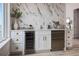 Wet bar featuring wine fridge, white cabinets, marble accent wall and natural light at 326 129Th E Ave, Madeira Beach, FL 33708