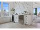 Wet bar featuring wine fridge, white cabinets, marble accent wall and natural light at 326 129Th E Ave, Madeira Beach, FL 33708