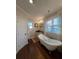 Bright bathroom featuring a clawfoot tub, dark hardwood flooring, and custom cabinets at 460 137Th Avenue Cir, Madeira Beach, FL 33708
