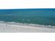 Aerial view of a sandy beach and ocean with small waves and a few beach goers in the distance at 460 137Th Avenue Cir, Madeira Beach, FL 33708