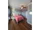 Comfortable bedroom with hardwood floors, ceiling fan, and a queen-sized bed with cheerful accents at 460 137Th Avenue Cir, Madeira Beach, FL 33708