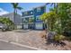 Lovely blue two-story home with a double garage, surrounded by lush tropical landscaping and a paved driveway at 460 137Th Avenue Cir, Madeira Beach, FL 33708