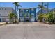 Charming two-story blue home with a double garage and a spacious paved driveway, surrounded by palm trees at 460 137Th Avenue Cir, Madeira Beach, FL 33708