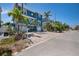 Inviting blue two-story home with a double garage, palm trees, and a well-maintained driveway and landscaping at 460 137Th Avenue Cir, Madeira Beach, FL 33708