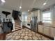 Well-lit kitchen with white cabinets, stainless steel appliances, and an adjacent staircase with unique wall decor at 460 137Th Avenue Cir, Madeira Beach, FL 33708