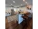 Spacious kitchen with white cabinetry, stainless steel appliances, bar seating, and stylish hardwood floors at 460 137Th Avenue Cir, Madeira Beach, FL 33708