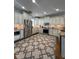 Bright kitchen featuring white cabinets, stainless steel appliances, and a stylish rug, perfect for cooking and gathering at 460 137Th Avenue Cir, Madeira Beach, FL 33708