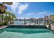 Infinity pool with stunning views of the intercoastal, a private dock, and nearby city buildings at 460 137Th Avenue Cir, Madeira Beach, FL 33708