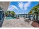 Inviting pool with a waterfront view and dock access, surrounded by lush landscaping and stylish patio furniture at 460 137Th Avenue Cir, Madeira Beach, FL 33708