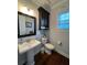 Powder room with dark cabinet, white pedestal sink and nautical decor at 460 137Th Avenue Cir, Madeira Beach, FL 33708