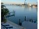 Waterfront view of a bay with personal watercrafts docked and palm trees on the shore and homes in the background at 460 137Th Avenue Cir, Madeira Beach, FL 33708