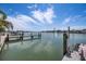 Picturesque waterfront view of the waterway and boat dock with a clear blue sky and fluffy clouds at 460 137Th Avenue Cir, Madeira Beach, FL 33708