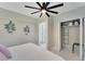 Bright bedroom with modern fan, accent wall decor, and closet with organizers at 4753 48Th N Ave, St Petersburg, FL 33714
