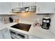Clean countertop with electric cooktop, stainless steel oven and coffee station at 4753 48Th N Ave, St Petersburg, FL 33714