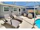 Covered patio with comfortable seating and lounge chairs near a sparkling pool at 4753 48Th N Ave, St Petersburg, FL 33714