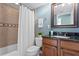 Bathroom with a shower and a vanity with dark wood cabinets at 5353 Gulf Blvd # B103, St Pete Beach, FL 33706
