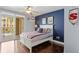 Cozy bedroom with dark wood floors, a ceiling fan, and balcony access at 5353 Gulf Blvd # B103, St Pete Beach, FL 33706