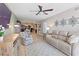 Open living room with neutral walls, ceiling fan, and views into the kitchen and dining area at 5353 Gulf Blvd # B103, St Pete Beach, FL 33706