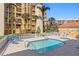 Inviting community pool area surrounded by comfortable lounge chairs, and tropical landscaping at 5353 Gulf Blvd # B103, St Pete Beach, FL 33706