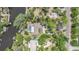Aerial view of a landscaped house with screened pool, dock and river access at 5910 River Rd, New Port Richey, FL 34652