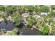 Aerial view of a house with a pool, dock, and lush greenery next to the river at 5910 River Rd, New Port Richey, FL 34652