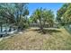 Backyard with screened pool, mature landscaping, canal, and pier at 5910 River Rd, New Port Richey, FL 34652