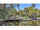 Backyard view from the canal showing a pier, a dock, and mature trees at 5910 River Rd, New Port Richey, FL 34652