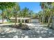 Inviting home with mature landscaping, charming arched entry, and a paved driveway leading to an attached garage at 5910 River Rd, New Port Richey, FL 34652