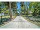 A long driveway leads to this home with mature trees and a white picket fence at 5910 River Rd, New Port Richey, FL 34652
