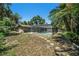 Screened in pool in backyard with stone stepper path, house with mature landscaping at 5910 River Rd, New Port Richey, FL 34652