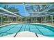 View of screened-in pool overlooking a lush green backyard and waterfront at 5910 River Rd, New Port Richey, FL 34652