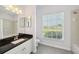 Bright bathroom with a white vanity, black countertop, and shower-tub combo at 6518 Paw Pl, Land O Lakes, FL 34639