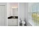 Bright bathroom with a white vanity, black countertop, and lots of natural light at 6518 Paw Pl, Land O Lakes, FL 34639