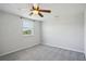 Carpeted bedroom with a ceiling fan and natural light from a window at 6518 Paw Pl, Land O Lakes, FL 34639