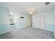 A spacious bedroom with carpet, light blue walls, ceiling fan, and a large window at 6518 Paw Pl, Land O Lakes, FL 34639
