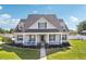 Charming home featuring a spacious front porch with rocking chairs and well-maintained landscaping at 6518 Paw Pl, Land O Lakes, FL 34639