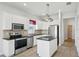 Modern kitchen with white cabinets, stainless steel appliances, and a center island at 6518 Paw Pl, Land O Lakes, FL 34639