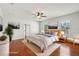 Virtually staged main bedroom with hardwood floors, ample natural light, and stylish decor at 6518 Paw Pl, Land O Lakes, FL 34639
