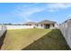 Spacious backyard with green grass and a white fence surrounding the perimeter of the property at 672 Old Windsor Way, Spring Hill, FL 34609