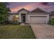 Charming single-story home featuring a well-manicured lawn, neutral paint, and an attached two-car garage at 672 Old Windsor Way, Spring Hill, FL 34609