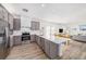 Well-lit kitchen featuring stainless steel appliances, gray cabinetry, quartz countertops, and wood floors at 672 Old Windsor Way, Spring Hill, FL 34609