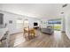 Open-concept living space featuring wood-look tile floors, large windows, and access to the backyard at 672 Old Windsor Way, Spring Hill, FL 34609